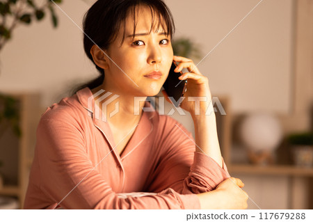 Young woman looking at her smartphone at night 117679288