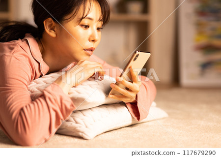 晚上看智慧型手機的年輕女子 117679290