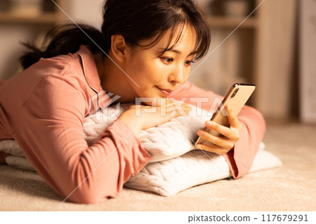 晚上看智慧型手機的年輕女子 117679291
