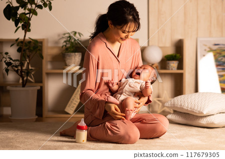 Mother holding baby crying at night Mother holding baby crying at night 117679305