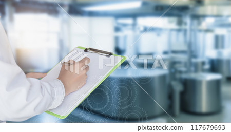 Engineer in lab coat writing in document . Engineer in lab coat writing in document . 117679693