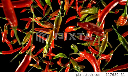 Hot red and green chilli peppers flying on black background. 117680431