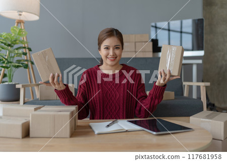 woman, online seller, efficiently manages customer orders and delivery through the e-commerce platform woman, online seller, efficiently manages customer orders and delivery through the e-commerce platform 117681958