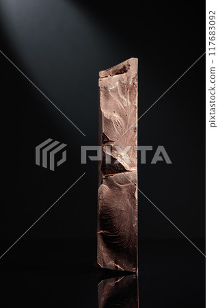 Large piece of dark chocolate. 117683092