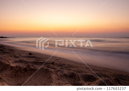 Seascape. Waves and surf. Sunset and dawn at sea. Calm on the ocean. Beautiful sky and clouds illuminated by the sun. Natural background. Summer time. Long exposure blurred water movement. 117683237