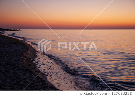 Seascape. Waves and surf. Sunset and dawn at sea. Calm on the ocean. Beautiful sky and clouds illuminated by the sun. Natural background. Summer time. 117683238