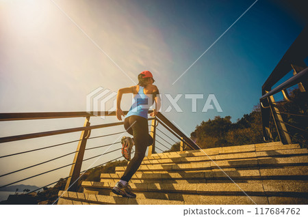 Healthy lifestyle sports woman running up on stone stairs at sunrise seaside Healthy lifestyle sports woman running up on stone stairs at sunrise seaside 117684762