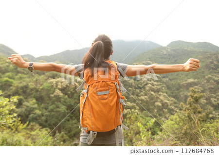 Cheering happy woman enjoying the view on morning mountain top 117684768