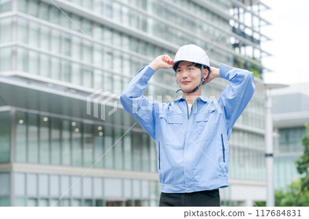 A man wearing a helmet and work clothes 117684831