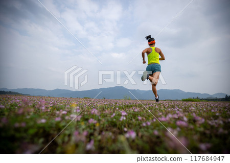 Woman runner running in spring Woman runner running in spring 117684947