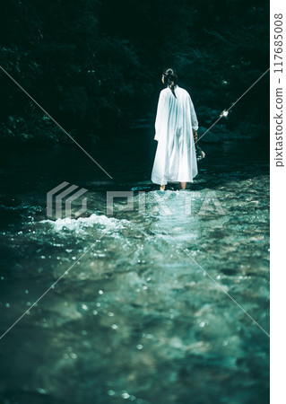The back view of a woman in a white dress swimming in a river in summer 117685008