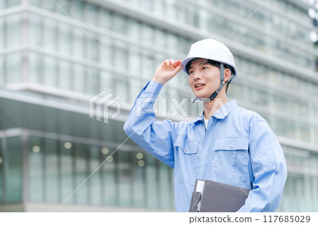 一個穿著工作服、戴著頭盔的男人 一個穿著工作服、戴著頭盔的男人 117685029