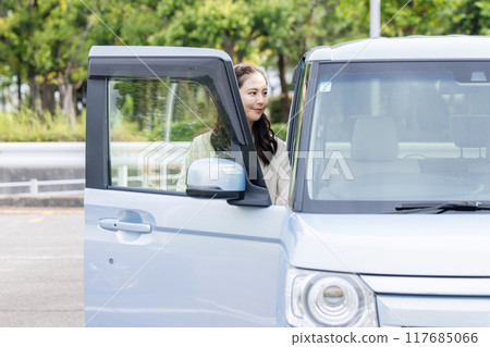 Young woman getting into a car Young woman getting into a car 117685066