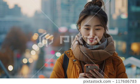 Asian woman's eyes are fixed on the screen, indicating her concentration 117686783