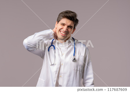 Tired doctor man feeling pain in neck joint, massaging muscles, rubbing head 117687609
