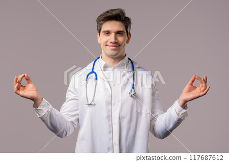 Calm doctor man relaxing, meditating, refuses stress. Hospital worker breathes 117687612
