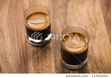 two shots of espresso on wood table two shots of espresso on wood table 117688063