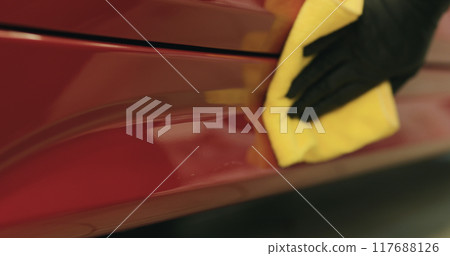 closeup of wiping red car with microfiber cloth 117688126