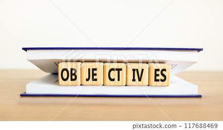 Objectives symbol. Concept word Objectives on beautiful wooden cubes in book. Beautiful wooden table white background. Business objectives concept. Copy space. Objectives symbol. Concept word Objectives on beautiful wooden cubes in book. Beautiful wooden table white background. Business objectives concept. Copy space. 117688469