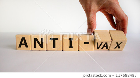 Anti-vax symbol. Doctor turns cubes with words 'anti-vax'. Beautiful white background. Copy space. Business, medical covid-19 vaccination or anti-vax concept. 117688485