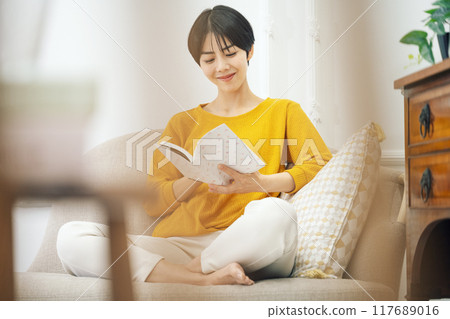 Woman enjoying reading on the sofa at home 117689016