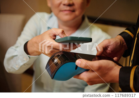 Man Using Smartphone To Pay For Bill In The Restaurant 117689317