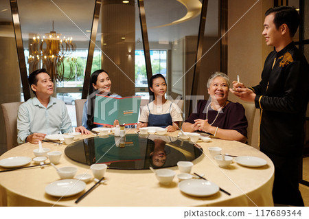 Family Examining Menu And Making Order Family Examining Menu And Making Order 117689344