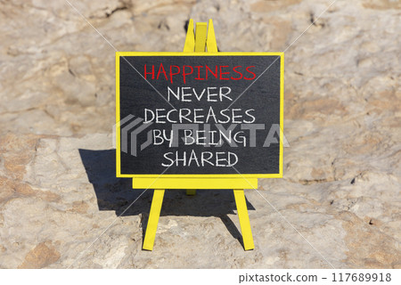 Happiness symbol. Concept words Happiness never decreases by being shared on beautiful black chalkboard. Beautiful sea stone beach background. Motivational Happiness concept. Copy space. Happiness symbol. Concept words Happiness never decreases by being shared on beautiful black chalkboard. Beautiful sea stone beach background. Motivational Happiness concept. Copy space. 117689918