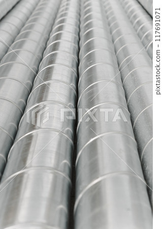 Ventilation duct pipes made of rolled steel in a warehouse, storage at a construction site Ventilation duct pipes made of rolled steel in a warehouse, storage at a construction site 117691071