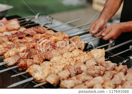 Frying shish kebab on the skewers in brazier. Fresh ruddy meat for barbecue grill on fire outdoor. Frying shish kebab on the skewers in brazier. Fresh ruddy meat for barbecue grill on fire outdoor. 117691088