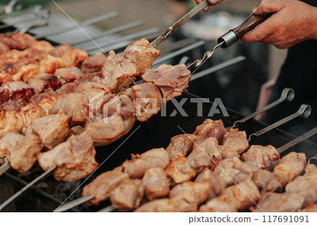 Frying shish kebab on the skewers in brazier. Fresh ruddy meat for barbecue grill on fire outdoor. Frying shish kebab on the skewers in brazier. Fresh ruddy meat for barbecue grill on fire outdoor. 117691091
