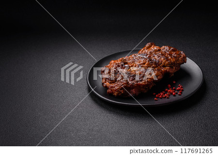 Fresh juicy delicious beef steak on a dark background Fresh juicy delicious beef steak on a dark background 117691265