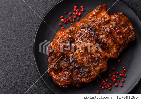 Fresh juicy delicious beef steak on a dark background 117691269