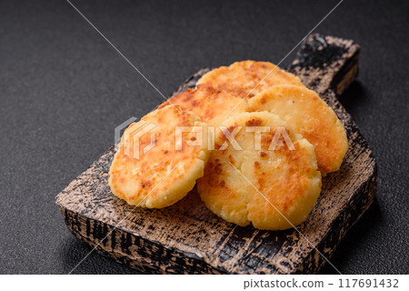 Delicious fresh sweet cheese pancakes with raisins and cinnamon Delicious fresh sweet cheese pancakes with raisins and cinnamon 117691432