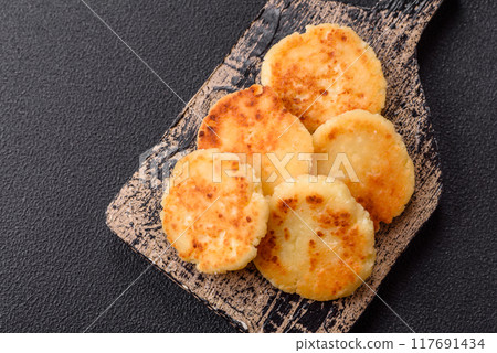 Delicious fresh sweet cheese pancakes with raisins and cinnamon Delicious fresh sweet cheese pancakes with raisins and cinnamon 117691434