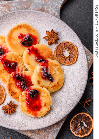 Delicious fresh sweet cheese pancakes with raisins and cinnamon Delicious fresh sweet cheese pancakes with raisins and cinnamon 117691458