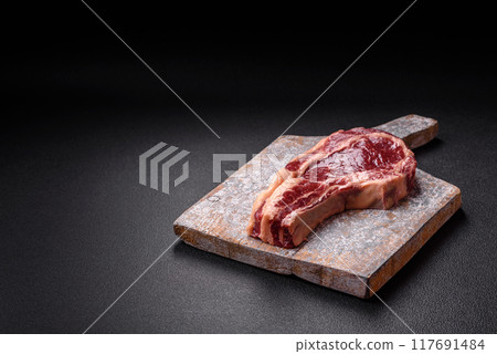 Fresh, raw beef steak with salt, spices and herbs Fresh, raw beef steak with salt, spices and herbs 117691484