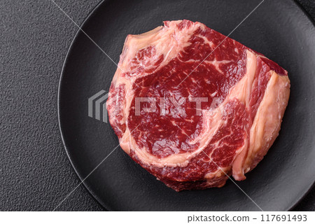 Fresh, raw beef steak with salt, spices and herbs Fresh, raw beef steak with salt, spices and herbs 117691493