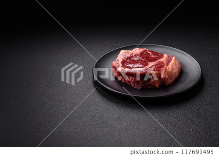 Fresh, raw beef steak with salt, spices and herbs 117691495