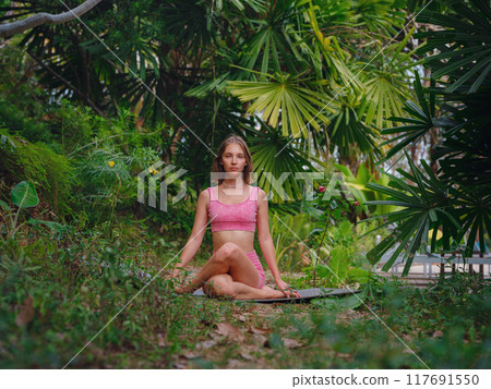 Beautiful woman practices yoga in Crabi, Thailand Beautiful woman practices yoga in Crabi, Thailand 117691550
