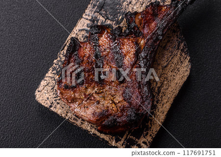 Juicy grilled beef tomahawk steak with salt, spices and herbs 117691751