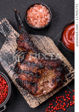 Juicy grilled beef tomahawk steak with salt, spices and herbs Juicy grilled beef tomahawk steak with salt, spices and herbs 117691755