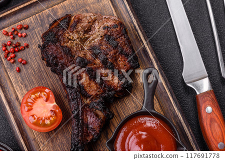 Juicy grilled beef tomahawk steak with salt, spices and herbs 117691778