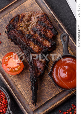 Juicy grilled beef tomahawk steak with salt, spices and herbs 117691779