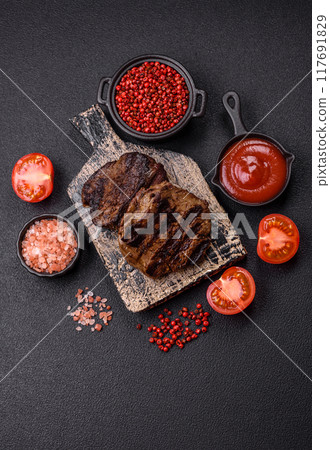 Fresh juicy delicious beef steak on a dark background Fresh juicy delicious beef steak on a dark background 117691829