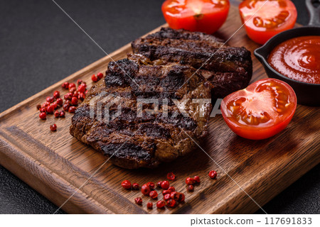 Fresh juicy delicious beef steak on a dark background Fresh juicy delicious beef steak on a dark background 117691833