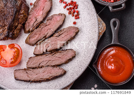 Fresh juicy delicious beef steak on a dark background Fresh juicy delicious beef steak on a dark background 117691849