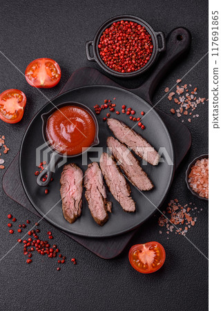 Fresh juicy delicious beef steak on a dark background Fresh juicy delicious beef steak on a dark background 117691865