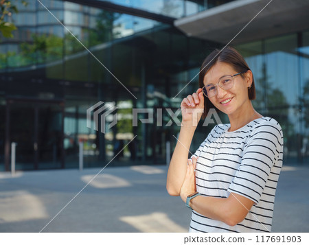 Asian woman over background of modern urban architecture in Vienna. Asian woman over background of modern urban architecture in Vienna. 117691903