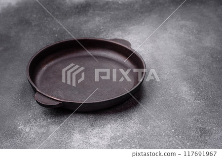 Empty ceramic plate on a dark textured background Empty ceramic plate on a dark textured background 117691967